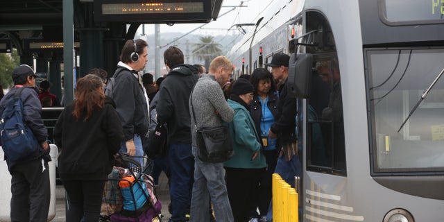 Pedestrians board a train at Union Station Friday March 7, 2014 in Los Angeles. Americans are boarding public buses, trains and subways in greater numbers than any time since the suburbs began to boom. Nearly 10.7 billion trips in 2013, to be precise, the highest number since 1956. (AP Photo/Nick Ut)