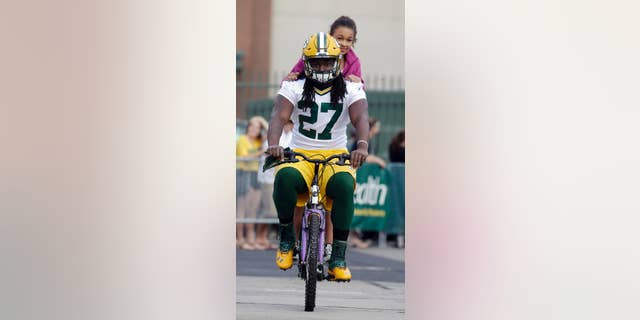 Green Bay Packers’ Eddie Lacy rides a bike to NFL football training camp on Saturday, July 26, 2014, in Green Bay, Wis. (AP Photo/Morry Gash)