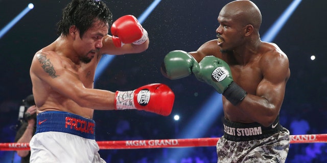 Manny Pacquiao, left, of the Philippines shields himself as Timothy Bradley throws a punch during the WBO welterweight title boxing fight Saturday, April 12, 2014, in Las Vegas. (AP Photo/Eric Jamison)