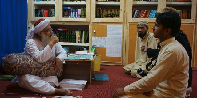 April 18, 2014 - Maulana Abdul Aziz, left, head cleric of a Pakistani seminary, in a library named after slain al Qaeda leader Usama bin Laden in Islamabad, Pakistan.