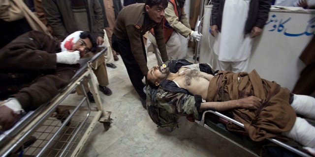 Dec. 25, 2010: Men injured in a suicide bomb attack in Pakistan's northwest Bajaur region are brought to Lady Reading Hospital in Peshawar for treatment. A burqa-clad bomber attacked a crowd of people waiting for aid in Pakistan on Saturday, killing at least 40 of them, officials said, showing militants' ability to strike despite army offensives.