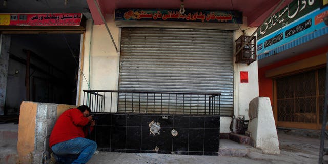 Nov. 11, 2013 - A photographer takes picture of the spot where Nasiruddin Haqqani, a senior leader of the feared militant Haqqani network, was assassinated at an Afghan bakery in the Bhara Kahu area on the outskirts of Islamabad, Pakistan.