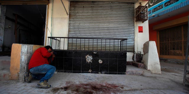 Nov. 11, 2013 - A photographer takes picture of the spot where Nasiruddin Haqqani, a senior leader of the feared militant Haqqani network, was assassinated at an Afghan bakery in the Bhara Kahu area on the outskirts of Islamabad, Pakistan.