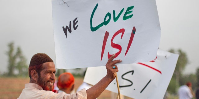 May 11, 2011: An activist associated with a social group from a citizen forum holds a placard as protesters rally in favor of Pakistan's army and Inter-Services Intelligence (ISI) in Islamabad.