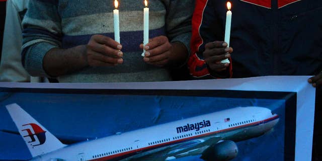 Members of the social group Christian Muslim Alliance Pakistan take part in a candlelight vigil for passengers that were aboard a missing Malaysia Airlines plane, Tuesday, March 18, 2014 in Islamabad, Pakistan. The search for Malaysian Flight 370, which vanished early March 8, 2014 while flying from Kuala Lumpur to Beijing with 239 people on board, has now been expanded deep into the northern and southern hemispheres. (AP Photo/Anjum Naveed)