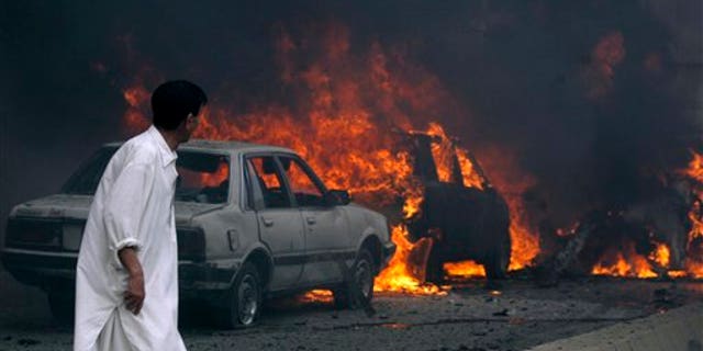 August 31: A Pakistani looks to burning cars after a suicide bombing in Quetta, Pakistan.