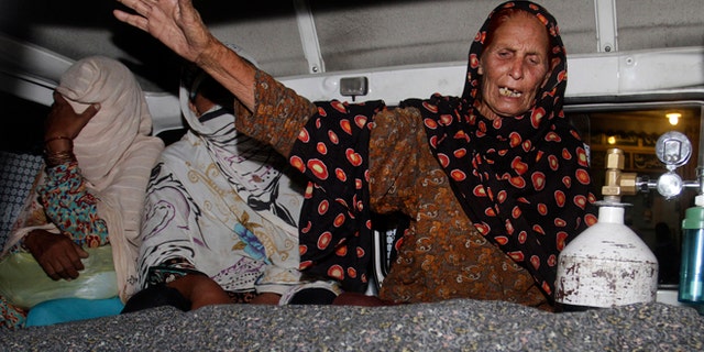 May 27, 2014: A family member of a pregnant woman who was stoned to death by her own family wails over her dead body in an ambulance at a local hospital in Lahore, Pakistan. (AP)