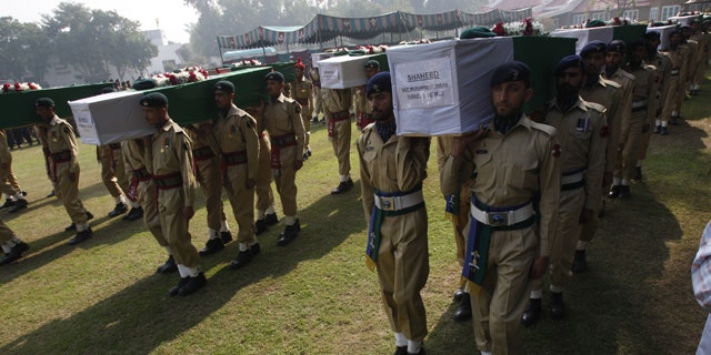 Nov. 27: Pakistan army soldiers carry coffin of Saturday's NATO attack victims for funeral in Peshawar, Pakistan.