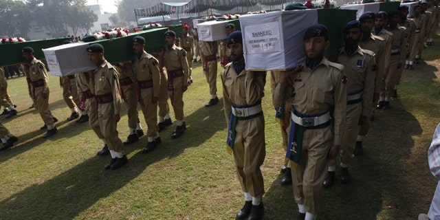 Nov. 27: Pakistan army soldiers carry coffin of Saturday's NATO attack victims for funeral in Peshawar, Pakistan.