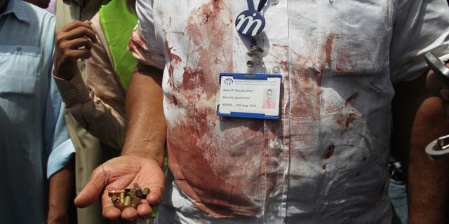 May 13, 2015: A Pakistani security official displays cartridges he collected from the scene of an attack on a bus in Karachi. Gunmen killed dozens of people on Wednesday aboard a bus in southern Pakistan bound for a Shiite community center, in the latest attack targeting the religious minority, police said. (AP Photo/Fareed Khan)