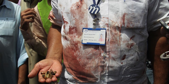 May 13, 2015: A Pakistani security official displays cartridges he collected from the scene of an attack on a bus in Karachi. Gunmen killed dozens of people on Wednesday aboard a bus in southern Pakistan bound for a Shiite community center, in the latest attack targeting the religious minority, police said. (AP Photo/Fareed Khan)