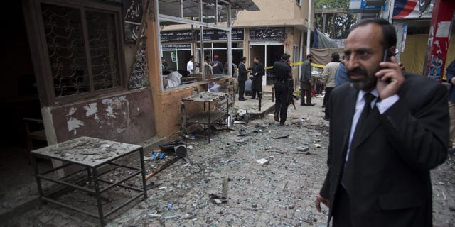 March 3, 2014: A Pakistani lawyer talks on his mobile phone at the site of a suicide attack in a court complex in Islamabad, Pakistan. Two suicide bombers blew themselves up at the complex on Monday, killing 11 people and wounding dozens in a rare terror attack in the heart of Islamabad, officials said. (AP Photo/B.K. Bangash)