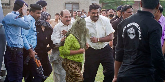 Sept. 8: Pakistani police officials escort a young Christian girl, center, accused of blasphemy for allegedly burning pages of a Quran, toward a helicopter following her release from central prison on the outskirts of Rawalpindi, Pakistan.