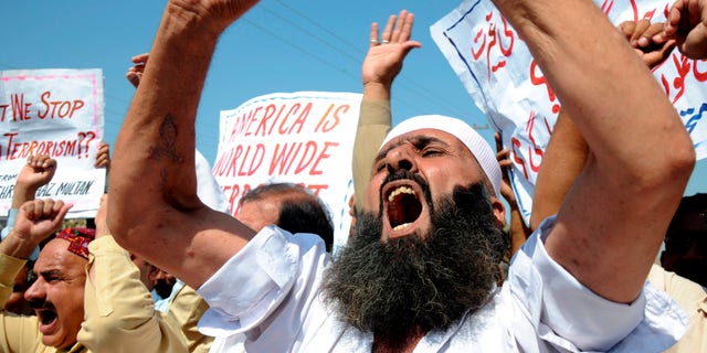 People shout anti-American slogans at a rally to condemn U. S. strikes on militants' hideouts in Pakistani tribal areas, in Multan, Pakistan on Friday, Oct 14, 2011.
