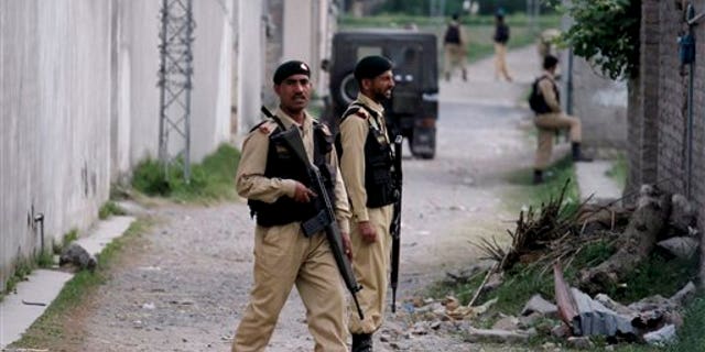 Pakistani army troops guarding the perimeter of the walled compound of a house where Al Qaeda leader Usama bin Laden was caught and killed by U.S. forces in Abbottabad, Pakistan.