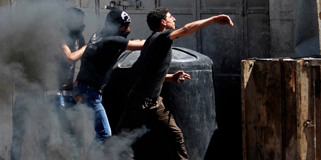 April 2, 2013: Palestinians throw stones at Israeli soldiers after the death of Maysara Abu Hamdiyeh in Israeli jail in the West Bank city of Hebron.