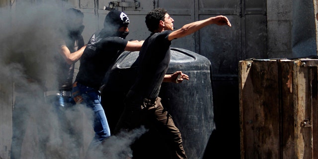 April 2, 2013: Palestinians throw stones at Israeli soldiers after the death of Maysara Abu Hamdiyeh in Israeli jail in the West Bank city of Hebron.