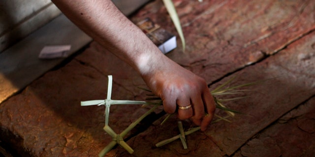 April 17, 2011: A Christian pilgrim places crosses made of palm fronds on the Anointing Stone inside the Church of the Holy Sepulcher, the site where many Christians believe Jesus was crucified and buried, in Jerusalem's Old City.