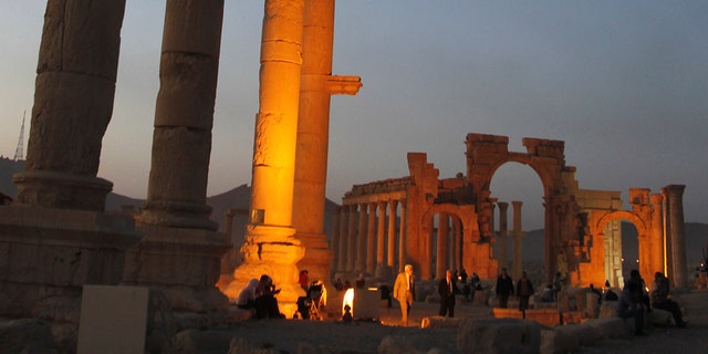 Tourists visit the ruined columns of the historical Palmyra city in the Syrian desert.
