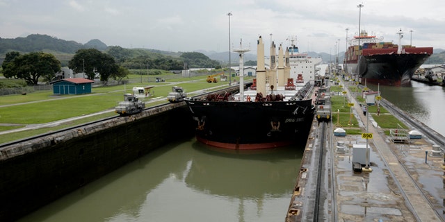 In this Aug. 4, 2014, photo, two cargo ships sails though the Miraflores locks on the Panama Canal in Panama City. (AP Photo/Arnulfo Franco)