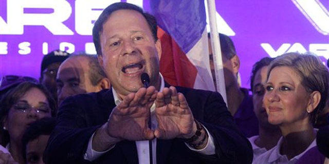 Juan Carlos Varela, Panama's president elect, delivers his acceptance speech as his wife Lorena Castillo, right, looks on in Panama City, Sunday, May 4, 2014. Varela was declared the victor of Panama's presidential election, thwarting an attempt by former ally President Ricardo Martinelli to extend his grip on power by electing a hand-picked successor. (AP Photo/Arnulfo Franco)