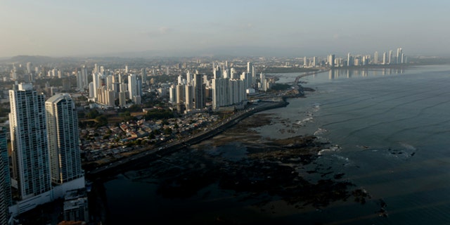 The setting sun lights up the Panama City skyline, Monday, April 4, 2016.