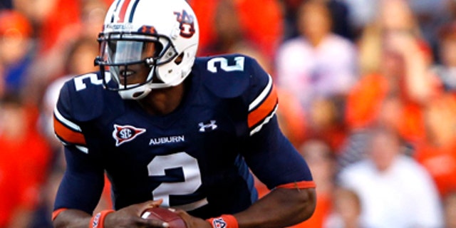 In this Sept. 4, 2010, file photo, Auburn quarterback Cameron Newton (2) runs for a first down against Arkansas State during an NCAA college football game in Auburn, Ala. (AP/File)
