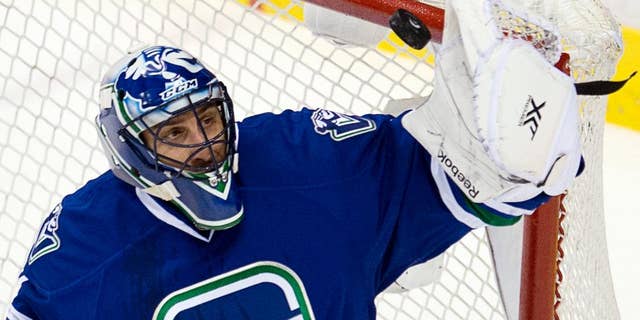 FILE - In this Jan. 29, 2014, file photo, Vancouver Canucks goalie Roberto Luongo makes a save during the first period of an NHL hockey game against the Chicago Blackhawks in Vancouver, British Columbia. Luongo was traded by the Canucks to the Panthers, who gave up goalie Jacob Markstrom and forward Shawn Mattias to make the deal happen. (AP Photo/The Canadian Press, Jonathan Hayward, File)