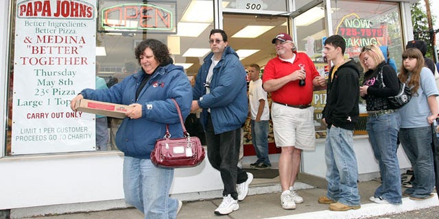 FILE: May 8, 2008: People leave a Papa John's store with pizzas they purchased for 23 cents in Medina Ohio .