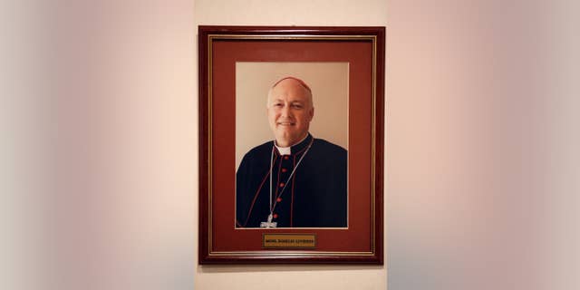FILE - This May 13, 2015 file photo shows a framed portrait of the ousted Bishop Rogelio Livieres Plano, that hangs on an office wall in Paraguay's Ciudad del Este diocese. The former Paraguayan bishop who was ousted by Pope Francis amid several controversies in his diocese has died of problems related to diabetes in a Buenos Aires hospital, Friday, Aug. 14, 2015. Livieres Plano was 69. (AP Photo/Jorge Saenz, File)