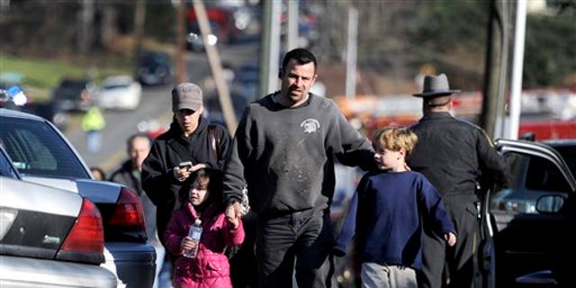 Parents leave a staging area after being reunited with their children following a shooting at the Sandy Hook Elementary School in Newtown, Conn.