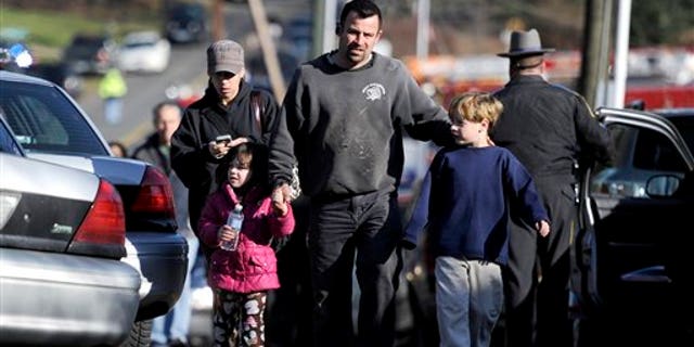 Parents leave a staging area after being reunited with their children following a shooting at the Sandy Hook Elementary School in Newtown, Conn.