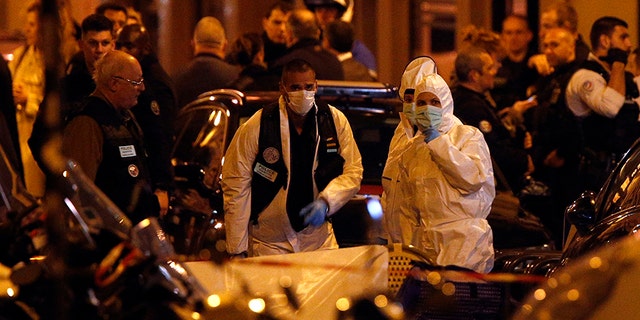 Scientific police officers investigate after a knife attack in central Paris, Saturday.