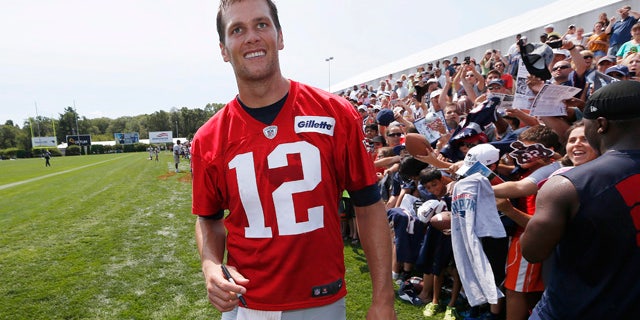 Aug. 1, 2015: New England Patriots quarterback Tom Brady walks down the line of fans signing autographs during an NFL football training camp in Foxborough, Mass. (AP Photo/Michael Dwyer)