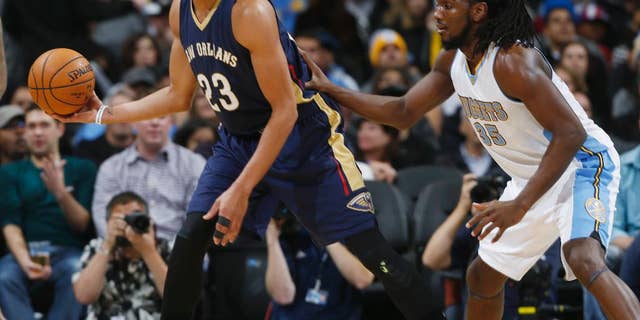 New Orleans Pelicans forward Anthony Davis, left, fields a pass as Denver Nuggets forward Kenneth Faried covers in the first quarter of an NBA basketball game in Denver, Friday, Nov. 21, 2014. (AP Photo/David Zalubowski)