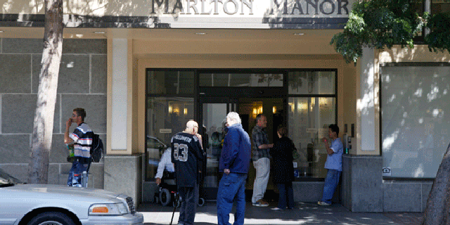 People gather outside the Marlton Manor public housing complex in San Francisco is photographed on Wednesday, April 7, 2010 where the FBI arrested resident Gregory Lee Giusti, 48, for allegedly making threatening and harassing phone calls to House Speaker Nancy Pelosi regarding health care reform. (AP)