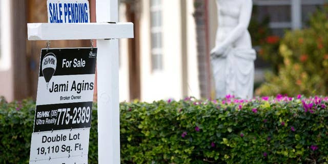 In this Thursday, Jan. 8, 2015 photo, a "sale pending" placcard is placed atop a realty sign outside a home for sale in Surfside, Fla. More Americans signed contracts to buy homes in February, the National Association of Realtors reported Monday, March 30, 2015, evidence that the spring buying season could open strong after sluggish sales for much of the winter. (AP Photo/Wilfredo Lee)