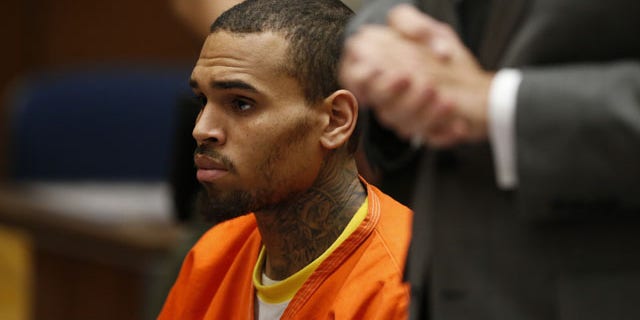 March 17, 2014: R&B singer Chris Brown, center, appears in Los Angeles Superior Court with his attorney Mark Geragos, right. Brown will spend another month in jail after a judge said Monday he was told the singer made troubling comments in rehab about being good at using guns and knives. (AP Photo/Lucy Nicholson, Pool)