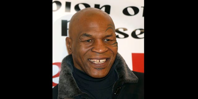 Feb. 16, 2013: File photo, former heavyweight champion Mike Tyson smiles during a promotional event for former five-time champion Evander Holyfield's Real Deal barbecue sauce at a Chicago grocery store.
