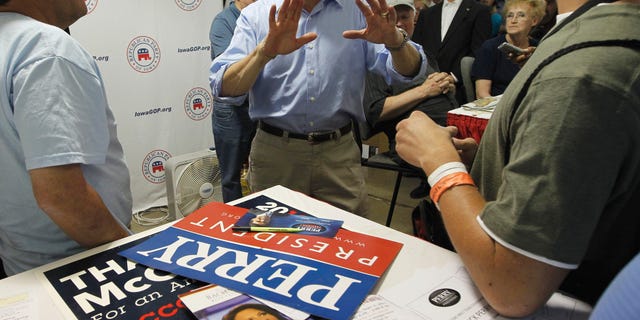 August 15: Flyers for Rep. Michele Bachmann, R-Minn. and former Alaska Gov. Sarah Palin can be seen on the table as Republican presidential candidate, Texas Gov. Rick Perry visits the Iowa GOP Booth at the Iowa State Fair in Des Moines.