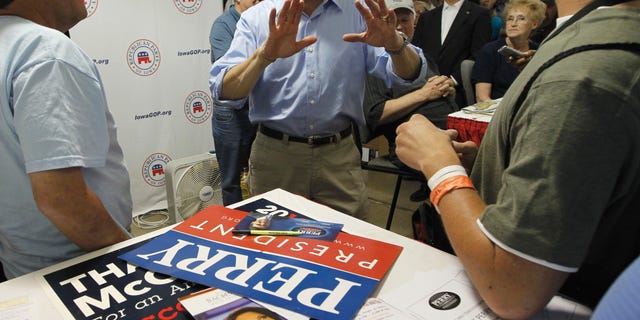 August 15: Flyers for Rep. Michele Bachmann, R-Minn. and former Alaska Gov. Sarah Palin can be seen on the table as Republican presidential candidate, Texas Gov. Rick Perry visits the Iowa GOP Booth at the Iowa State Fair in Des Moines.