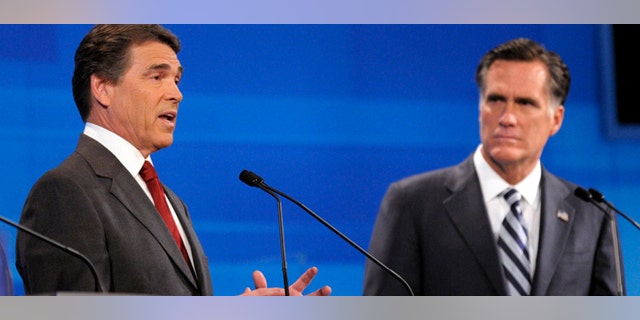 Republican presidential candidate former Massachusetts Gov. Mitt Romney, right, listens as Texas Gov. Rick Perry makes a statement during a debate Thursday, Sept. 22, 2011, in Orlando, Fla. (AP Photo/Phelan M. Ebenhack, Pool)