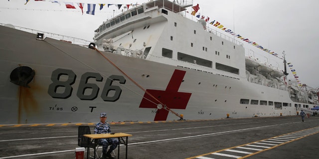 A Chinese official sits in front of Chinese naval hospital ship in the port of Callao, Peru, Tuesday, Dec. 22, 2015. The Peace Ark, a Chinese naval hospital ship is making a first-ever call into a South American port in a sign of the Asian economic giants growing influence in Washingtons backyard. Its the last destination on a three-month Harmonious Mission that also included stops in Australia, Mexico and the U.S. (AP Photo/Martin Mejia)