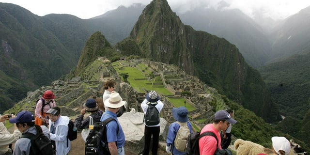 Tourists look at the Inca citadel of Macchu Picchu in Peru. The government is looking to shift some of the tourist burden from Machu Picchu, to Choquequirao, with a plan to build the first aerial tramway that will make Choquequirao reachable in just 15 minutes from the nearest highway.