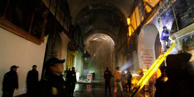 Firefighters and police inspect the famed 16th century San Sebastian church after it was partially destroyed by fire in Cuzco, Peru, Friday, Sept. 16, 2016. The blaze that burned into Friday morning destroyed the ornate, gilded altar and about two dozen paintings at the Temple of San Sebastian. (AP Photo/Percy Hurtado)