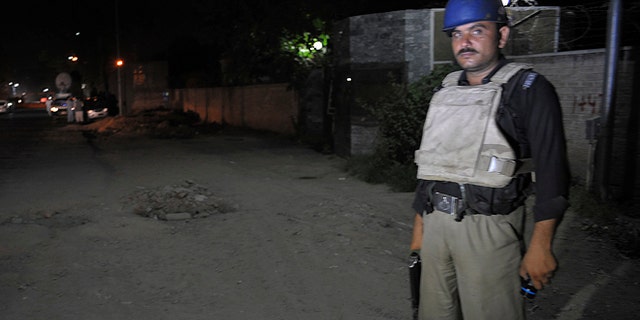 June 25, 2014: A Pakistani police officer stands guard near Peshawar airport which is cordoned off, in Pakistan. Authorities in Pakistan were looking for a gunman who opened fire at a plane Tuesday evening just as it was landing in the volatile northwest, killing one person and wounding two others, officials said, casting fresh doubts about security at the country's airports.