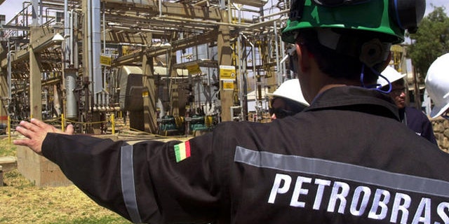 A Bolivian employee of Brazil's oil giant Petrobras subsidiary Petrobras Bolivia shows a natural gas facility at the Gualberto Villarroel , 8m (about 5 miles) south of Cochabamba, Bolivia, Tuesday, Sept. 5, 2006. The nationalization of Bolivia's hydrocarbons industry took two steps forward this week as the government opened long-awaited contract negotiations with foreign petroleum companies while collecting the first round of higher royalties it now charges those firms. Representatives of the French company Total S.A. sat down with Hydrocarbons Ministry officials Tuesday in La Paz to begin drawing up a new contract ceding a majority share of their Bolivian operations to the government, as required by President Evo Morales' May 1 nationalization decree. Contract negotiations with other international firms _ including Brazil's state-owned Petrobras and the Spanish-Argentine firm Repsol YPF _ are expected to follow.(AP Photo/Nano Cartagena)