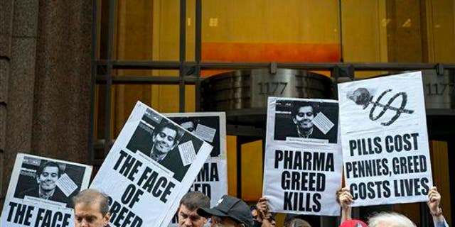 Activists hold signs containing the image of Turing Pharmaceuticals CEO Martin Shkreli in front of Turing's offices in New York on Oct. 1, 2015, during a protest.