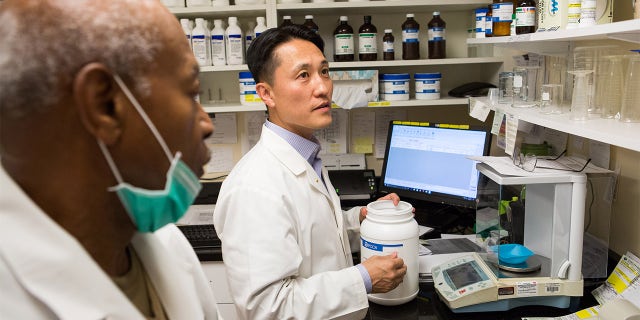 On October 6, 2017, Dr. Michael Kim (center), a pharmacist and owner of Grubb's Pharmacy, prepares medication in the compound of his Northeast, Washington D.C. store with Ron Thompson(left, Compound Technician). Grubb's Pharmacy, established in 1867, is the oldest pharmacy in D.C., and with its convenient location to the U.S. Capitol, services many Members of Congress.