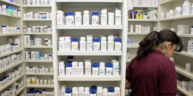A pharmacy employee looks for medication as she works to fill a prescription while working at a pharmacy in New York December 23, 2009. REUTERS/Lucas Jackson (UNITED STATES - Tags: HEALTH POLITICS) - RTR28BCM